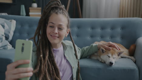woman taking a selfie with her dog on the sofa