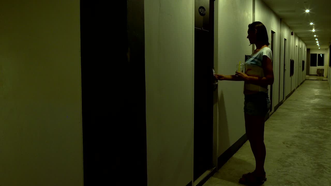 Woman walks down the hallway and walks into the room