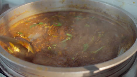 adornando el curry con jengibre y hojas de curry en un recipiente