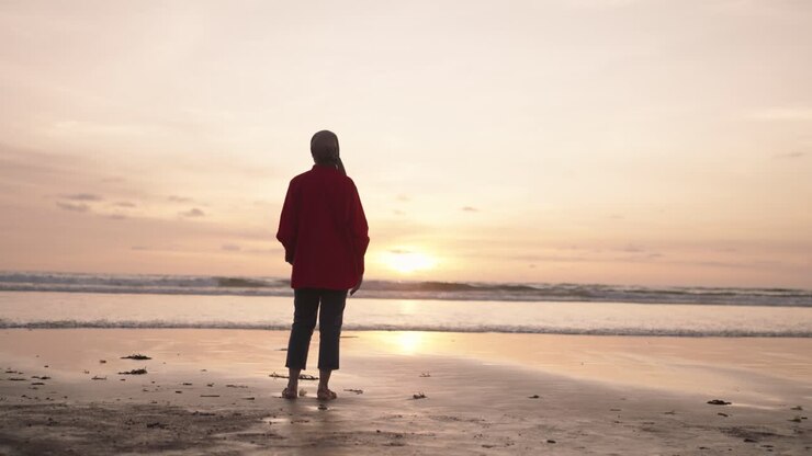 夕暮れのビーチの女性