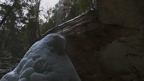 water flowing down on ice cone formed under the waterfall during winter in ash cave in ash cave clip 18