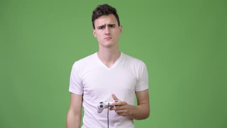 young handsome man playing games while using virtual reality headset