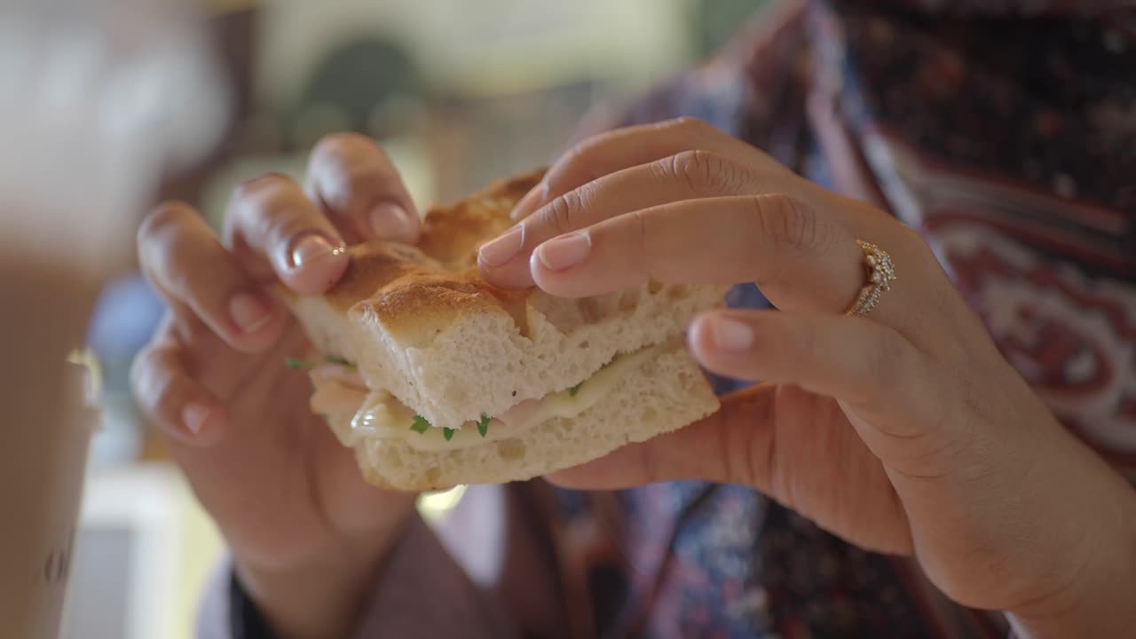 Una mujer comiendo un sándwich.