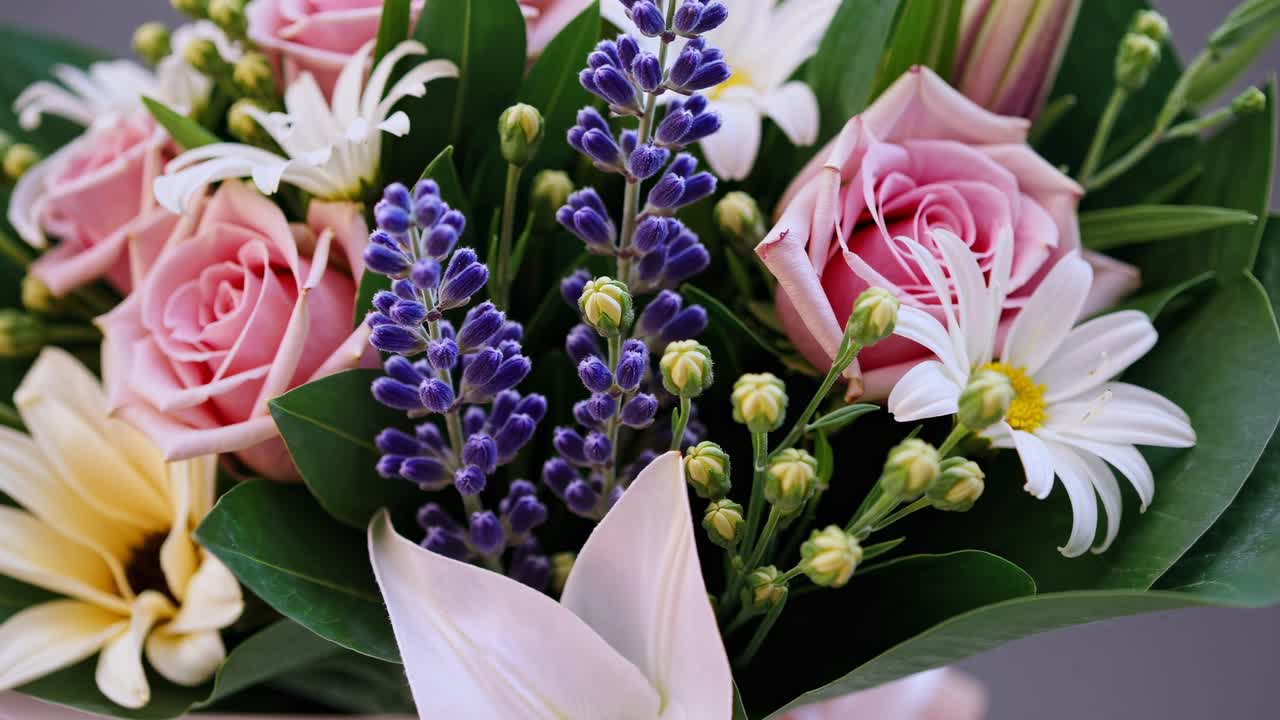 Close-up video of a vibrant flower bouquet featuring pink roses, daisies, and lavender