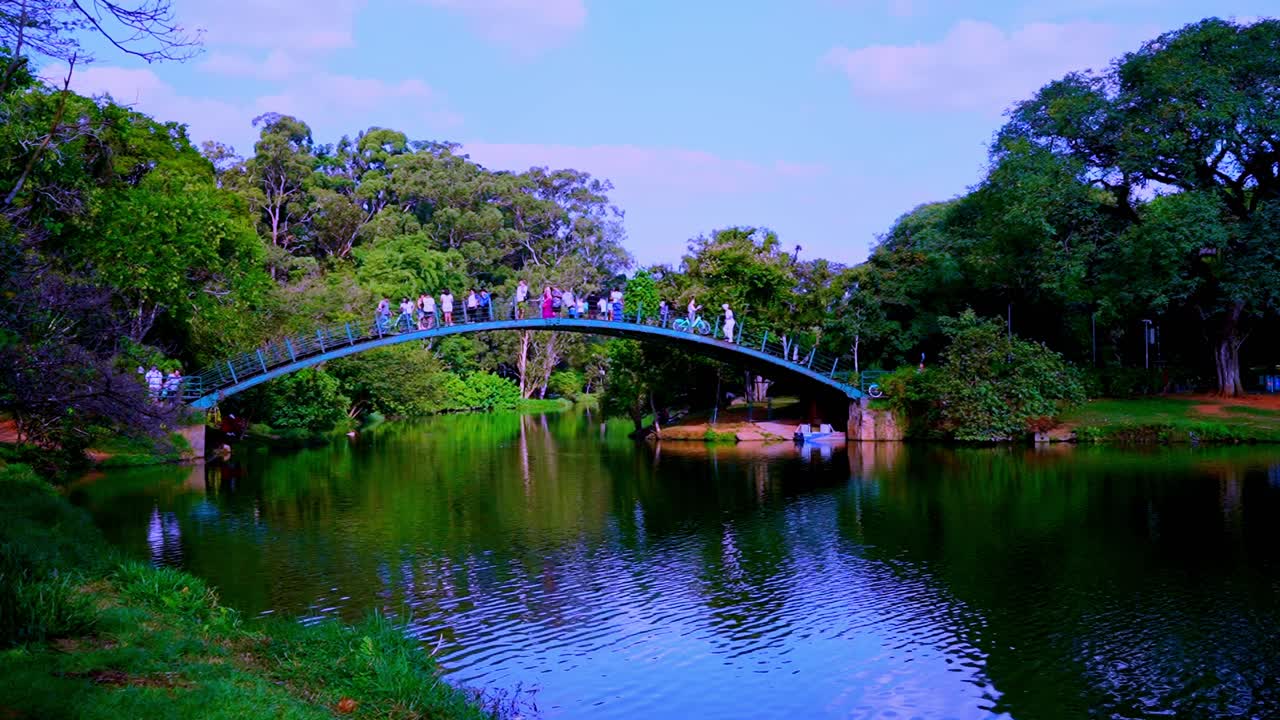 ibira lake in São Paulo tourist walking on romantic bridge taking selfie of famous landmark in urban park