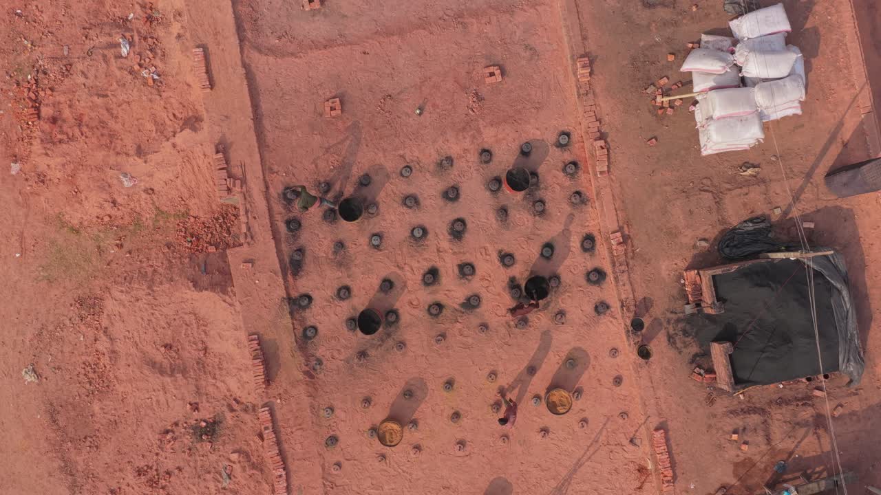 Riprese aeree di fornaci di mattoni con fumo e operai in Bangladesh.