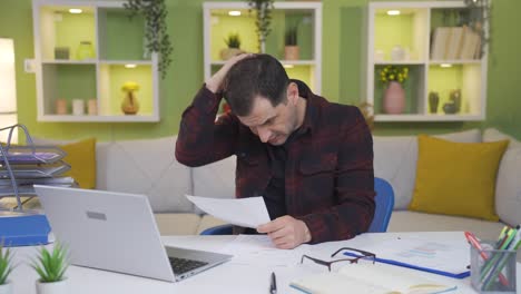 hombre que trabaja desde casa asustado, estresado y abrumado por un mal flujo de trabajo.