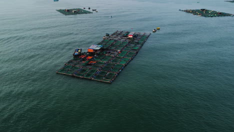 Aerial-circling-shot-of-coastal-zone-with-fish-farming,-Vietnam