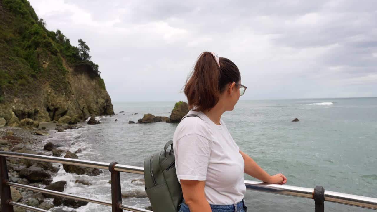 Woman admiring the Cantabrian Sea from Abra Viewpoint in Laredo, Cantabria on a cloudy day