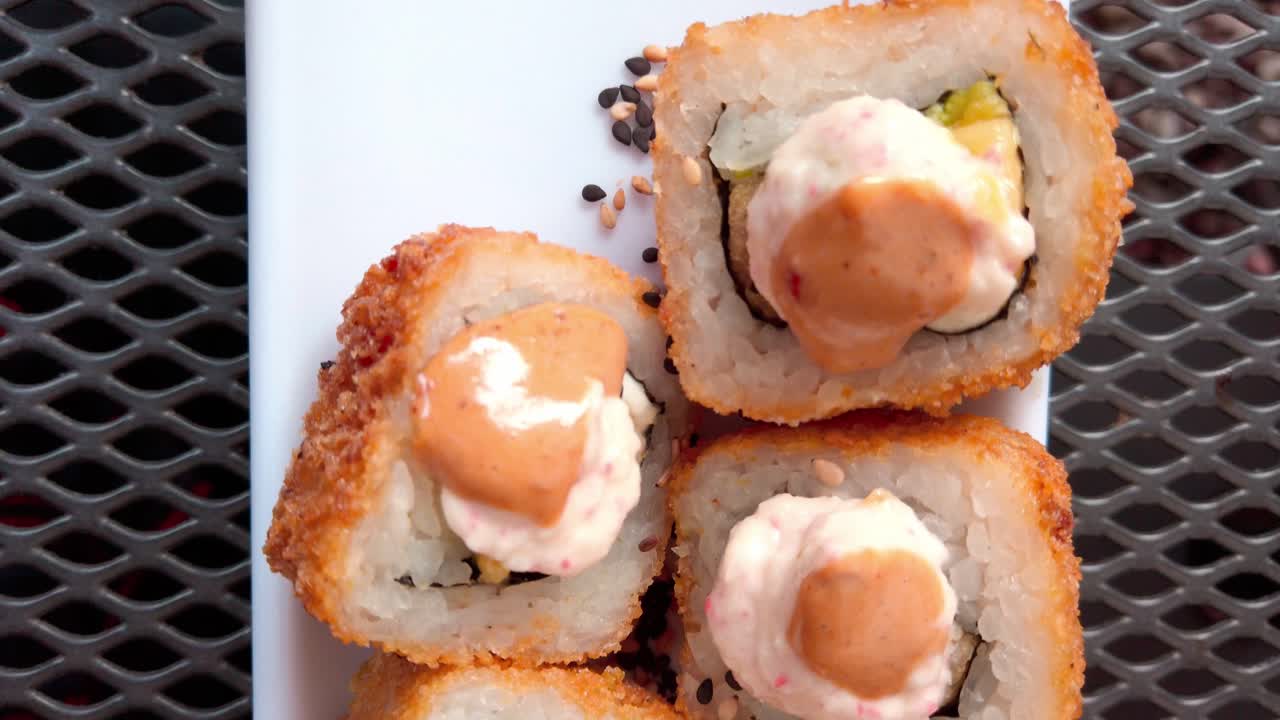 Crispy sushi rolls topped with spicy mayo and garnished with sesame seeds