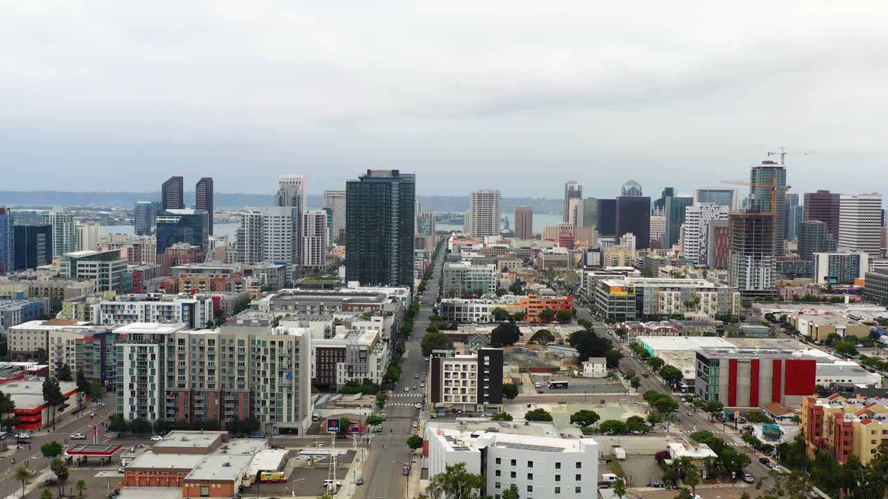 Drone che si allontana dallo skyline del centro di San Diego rivelando gli edifici circostanti e la disposizione della città alla luce del mattino