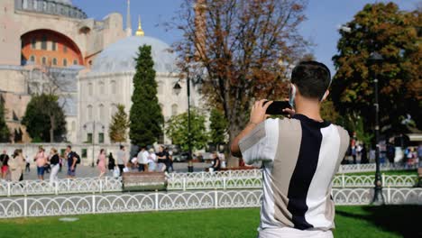 medium shot of a young man taking photos of hagia sophia