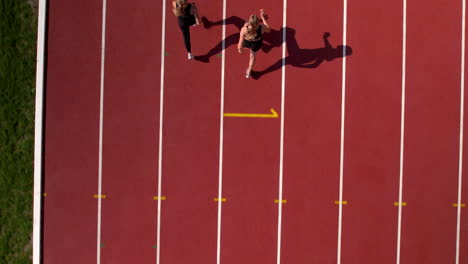 two female athletes running on a track