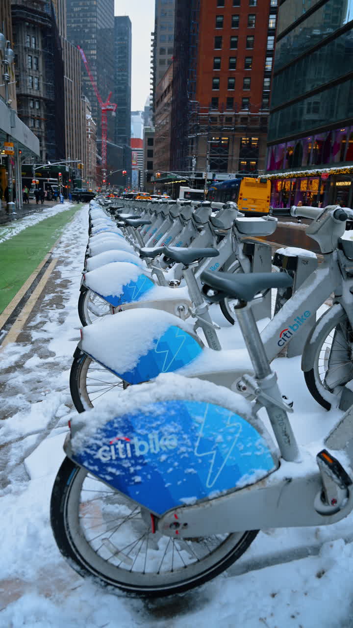 New York, USA, 24 December 2025: Snowy Citi Bike row in Midtown. Row of Citi Bikes covered with snow along Midtown Manhattan street
