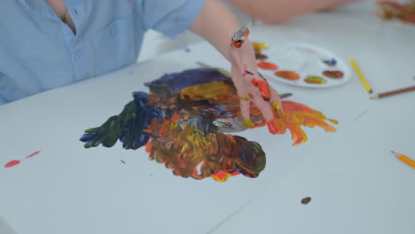 close-up-children-draw-their-fingers-on-paper-using-paints