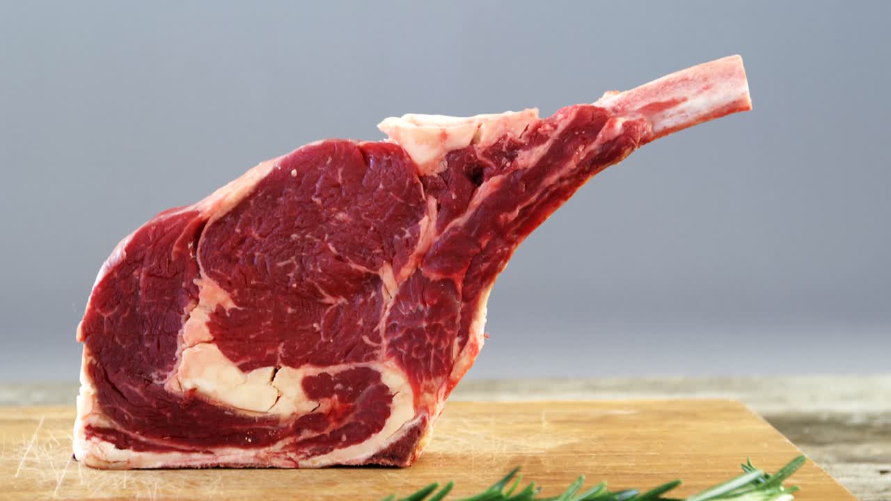 chuletas de carne cruda en tablero de madera