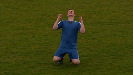 Jugador-De-Fútbol-Vestido-De-Azul-Celebrando-Una-Victoria.