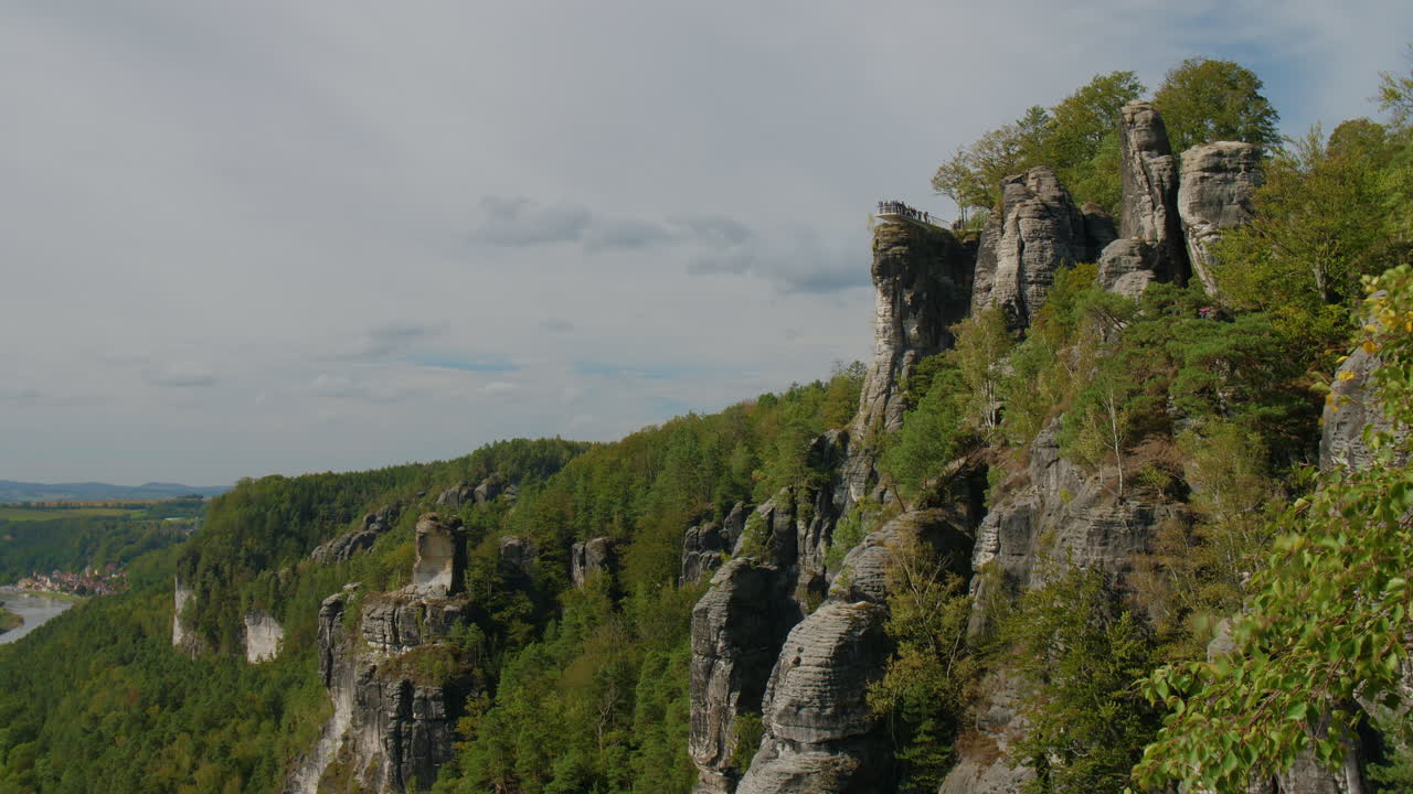 Observation platform Elbsandsteingebirge Sachsen Elbe sandstone formations rising above dense green forests Mountains, under a blue sky with scattered Clouds natural beauty and rugged Terrain