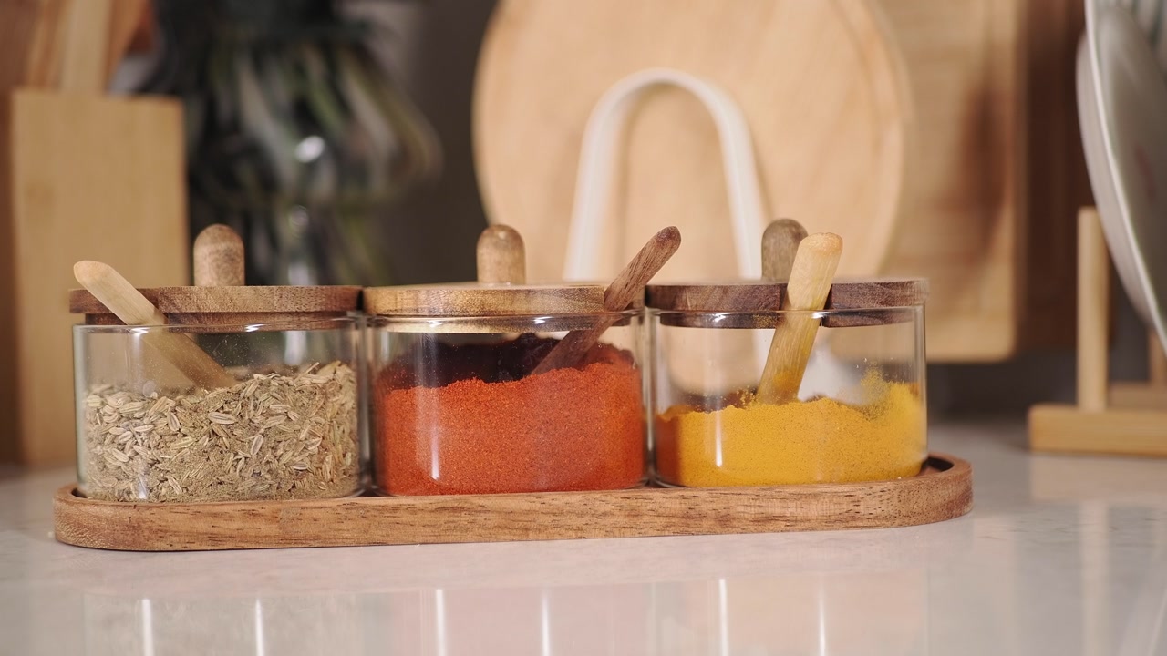 Three Glass Spice Jars with Paprika, Turmeric, and Fennel Seeds