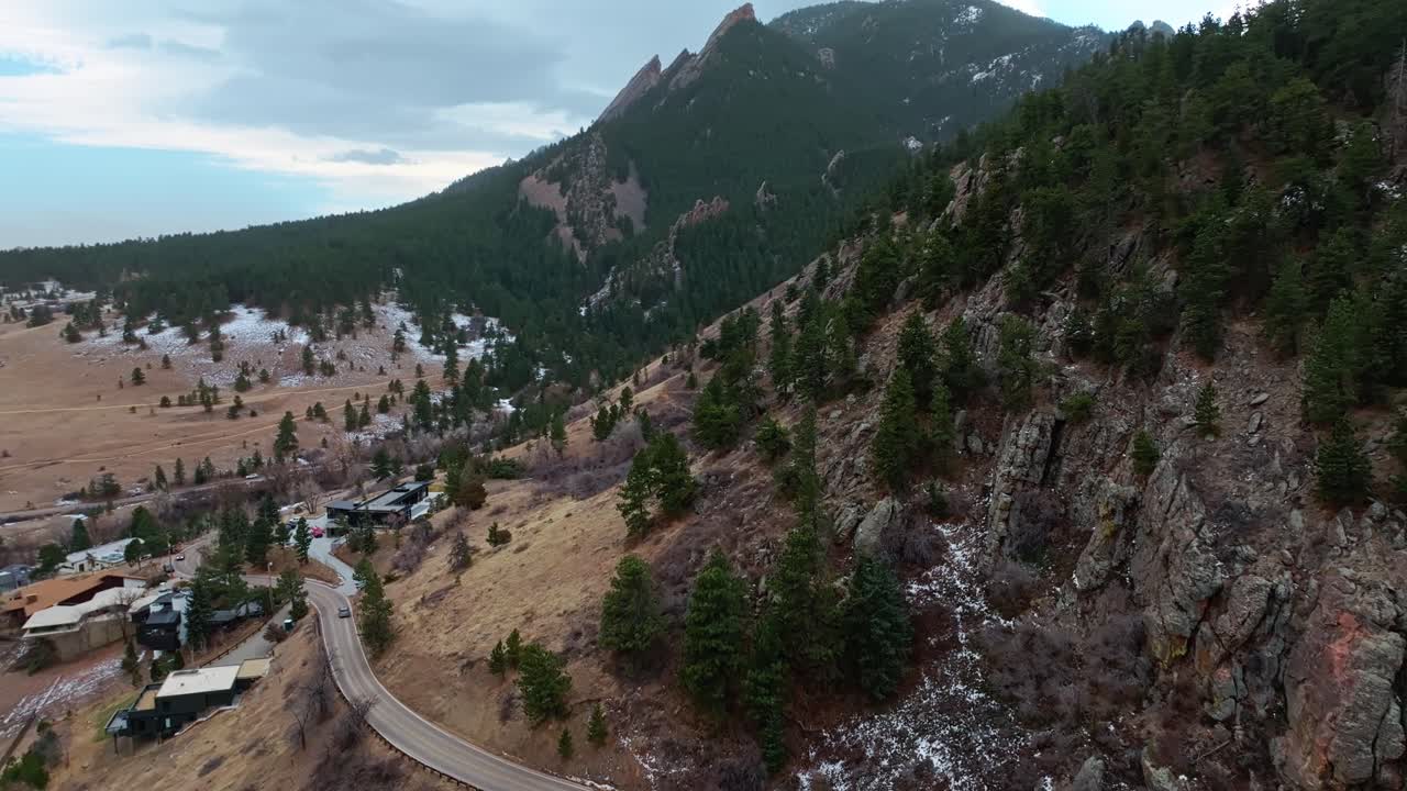Low angle drone establishing of Boulder Flatirons under golden sunlight, highlighting rock textures