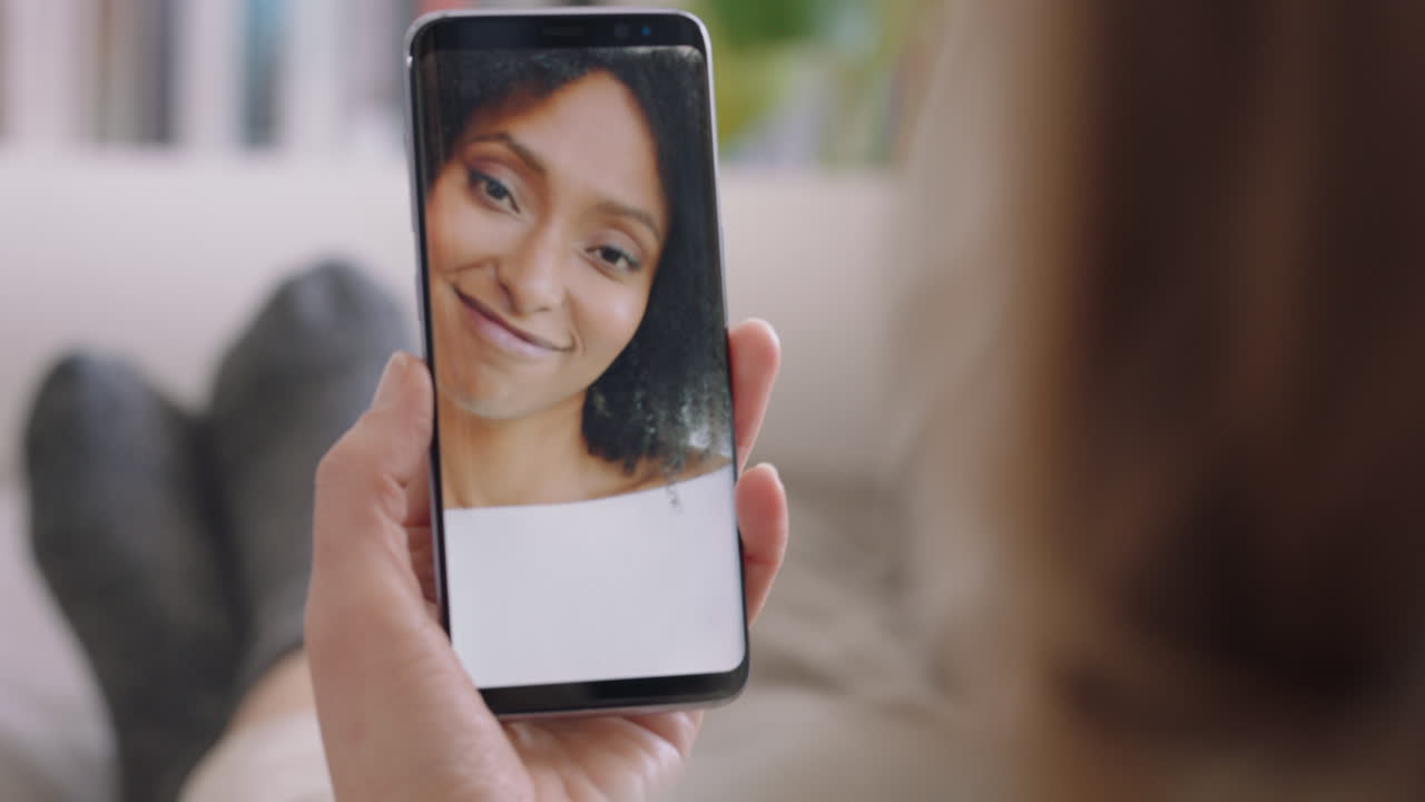 mujer joven teniendo video chat usando teléfono inteligente en casa hablando con un amigo disfrutando de la conversación compartiendo estilo de vida en el teléfono móvil orientación vertical 4k metraje