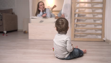 Baby-Spielt-Mit-Spielzeug,-Während-Es-Zu-Hause-Auf-Dem-Boden-Sitzt