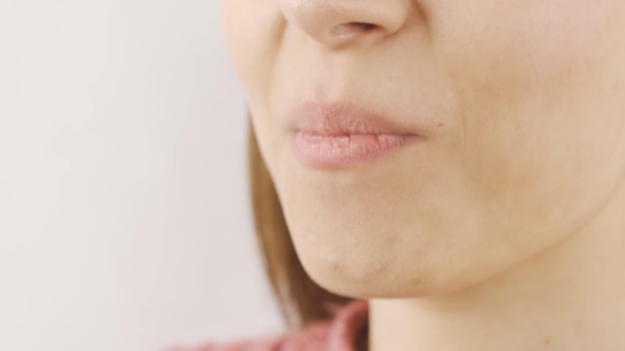 una mujer comiendo pistacho en primer plano.