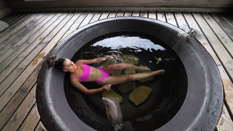 mujer relajándose en una bañera de agua caliente
