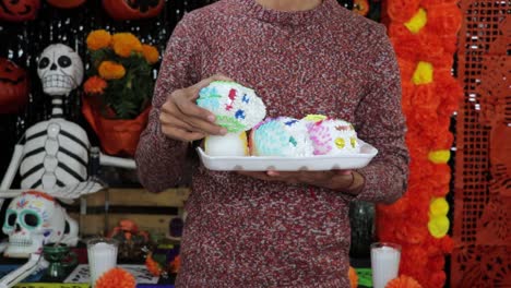 holding tray with sugar skulls candy for día de los muertos altar