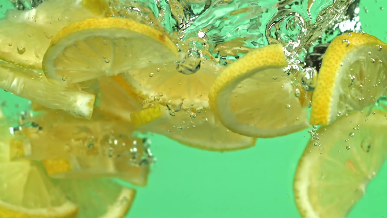 Slow Motion of Fresh Lemon Slices and Peels Falling into Water