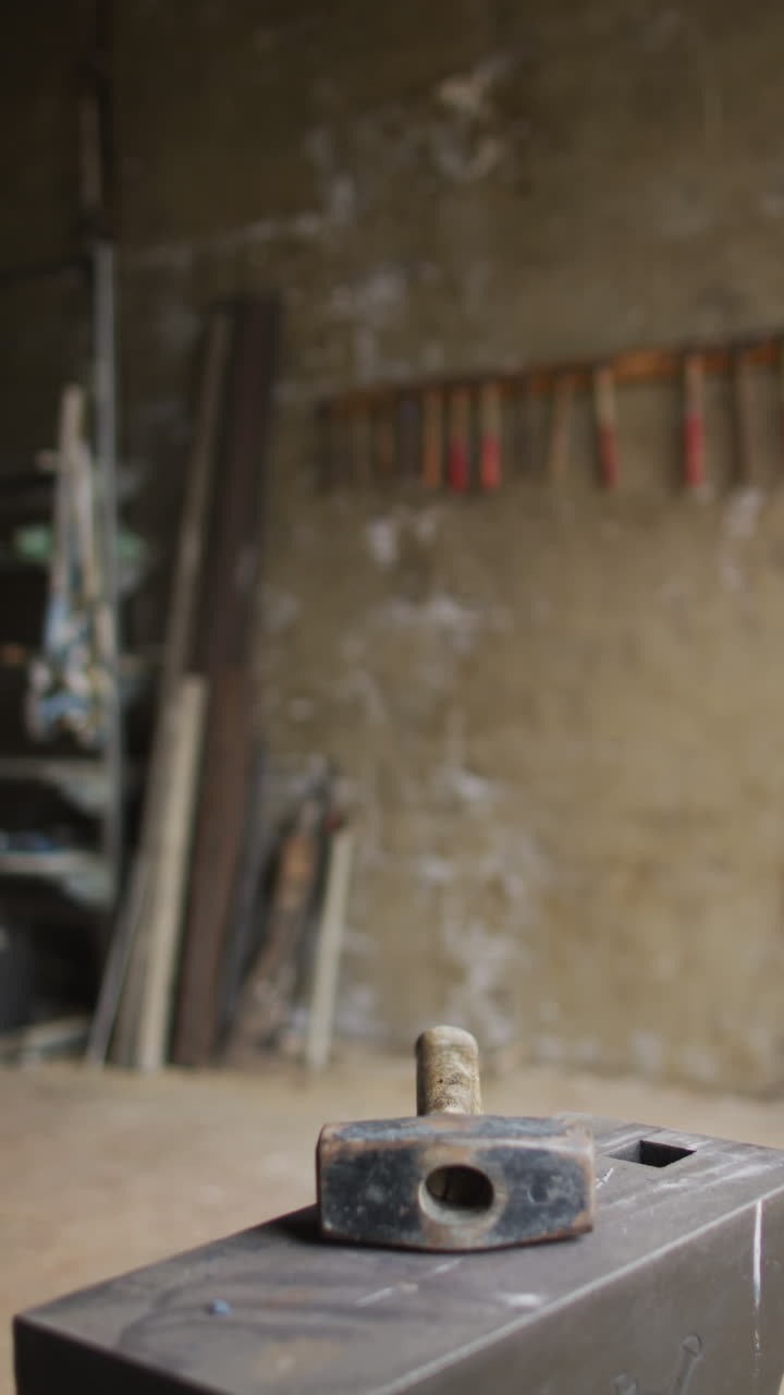 vídeo vertical del martillo en el banco de trabajo en el taller de metalurgia