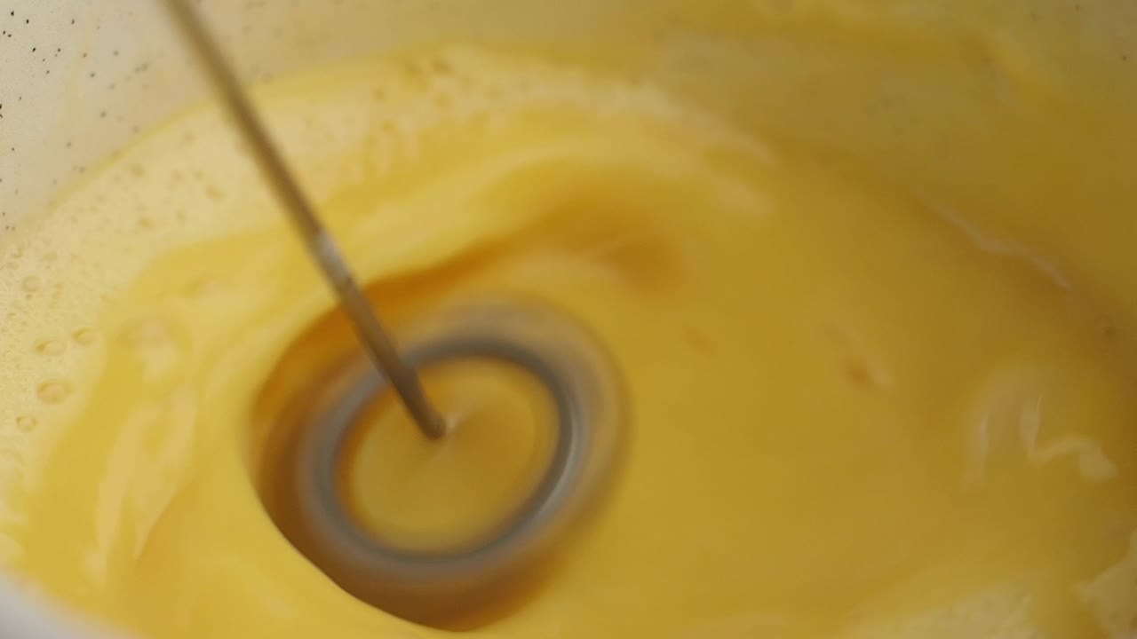 Mixing a yellow custard or sauce in a pot