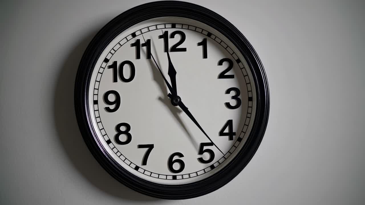 Close-up video shot of a classic wall clock at an eye-level angle, highlighting the simplicity