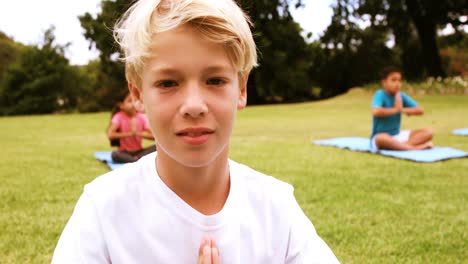 portrait of boy performing yoga in park