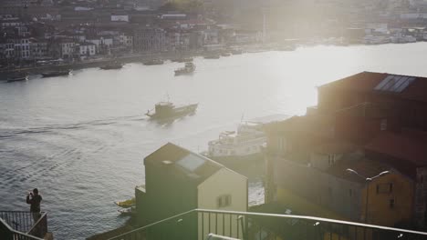 Atemberaubendes-Sonnenlicht-Scheint-Hell-über-Dem-Fluss-Douro-Mit-Booten-In-Der-Stadt-Porto,-Langsam