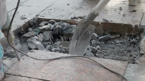 construction workers breaking up concrete pavement