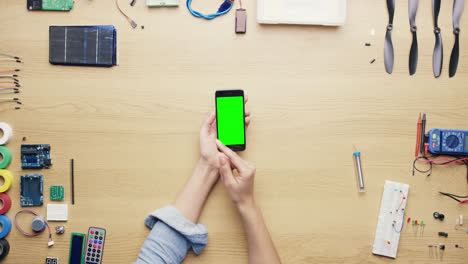 Top-view-woman-software-engineer-using-smartphone-touchscreen-at-desk-from-above---Red-Epic-Dragon