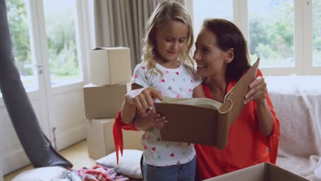 Mother-and-daughter-reading-story-book-at-new-home-4k