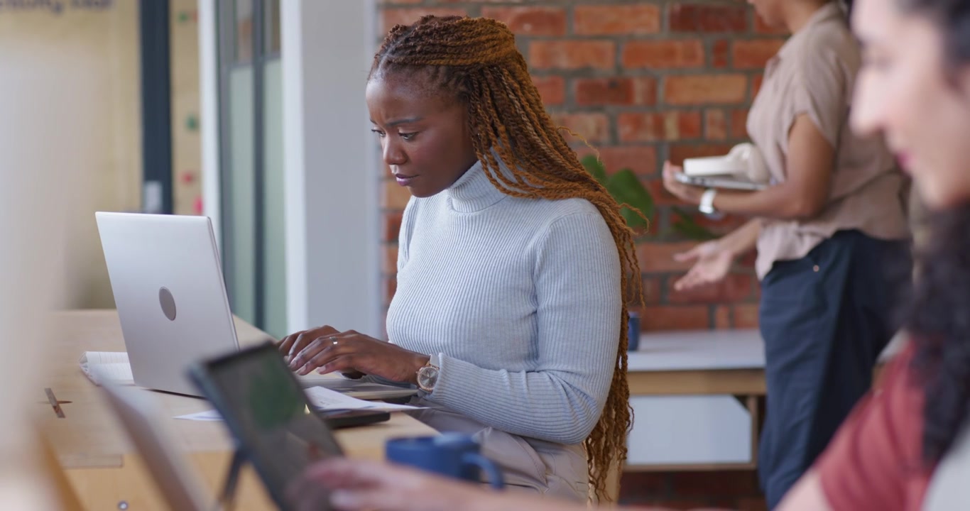 Woman positioning laptop, consulting notebook and typing at counter for work, copy space