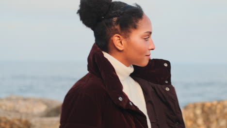 una chica afroamericana caminando por el mar.