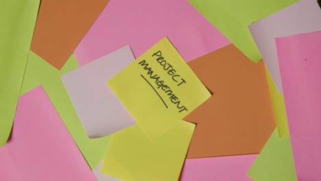 business concept of revolving sticky notes with project management written on top note