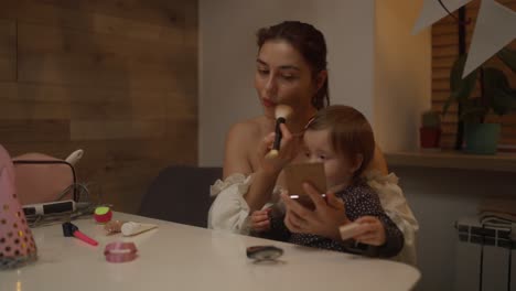 mother and daughter playing with makeup