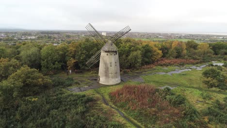 Traditionelle-Holzmühle-Windmühle-Aus-Holz-Stein-Erhalten-Im-Herbst-Wald-Luftbild-Landschaft-Absteigend