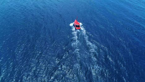 Barco-De-Pesca-Rojo-Tradicional-Cruzado-De-Abajo-Hacia-Arriba,-Vista-Aérea-Estática-De-Pájaro,-Agua-De-Mar-Brillante