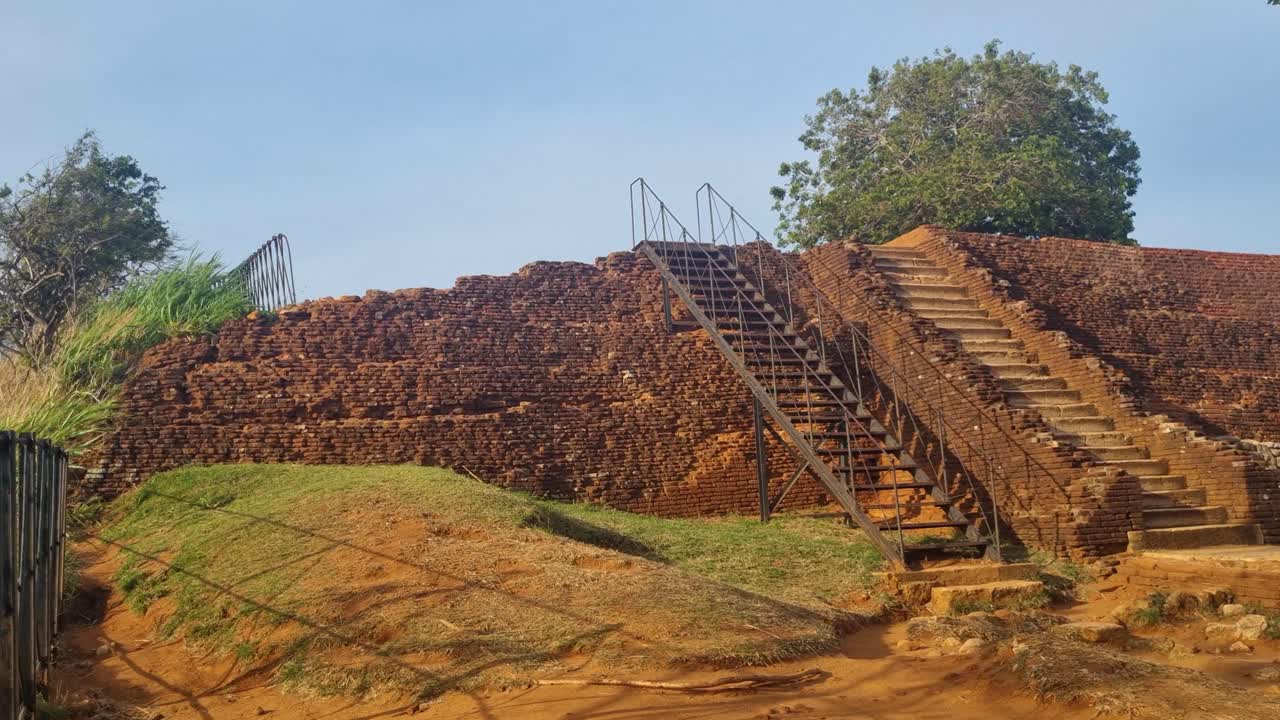 Vista dalla cima di Sigiriya in Sri Lanka, che mostra le rovine del palazzo e della fortezza del V secolo in cima a Lion Rock, circondata da una fitta vegetazione tropicale in una serata ventilata