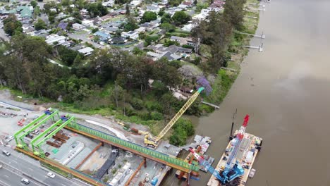 aerial view of anew bridge construction next to an existing highway bridge with residential suburb in the background
