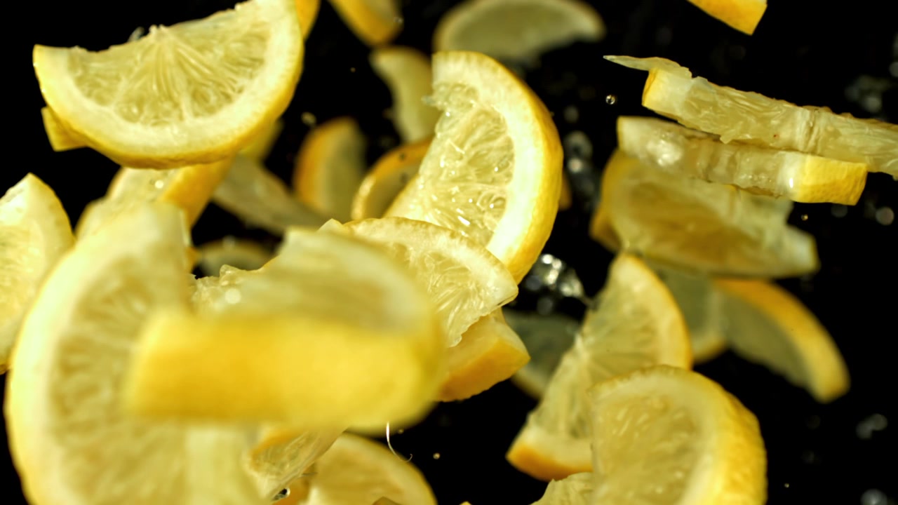 Fette di limone vivaci con goccioline d'acqua al rallentatore