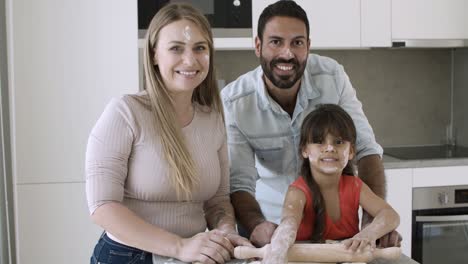 padres feliz pareja y niña con harina en las caras