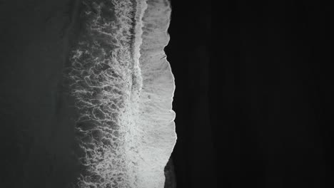 Filmische-Antenne-Von-Oben-Nach-Unten-Zum-Schwarzen-Sandstrand,-Wellen,-Die-Auf-Vulkanischem-Sand-Island-Krachen,-Filmische-Stimmung