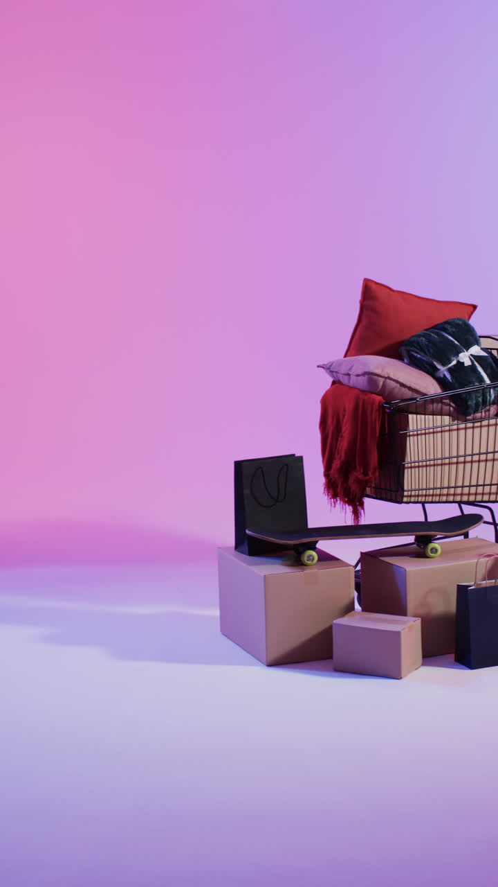 Vertical video of shopping trolley and shopping with copy space over pink neon background